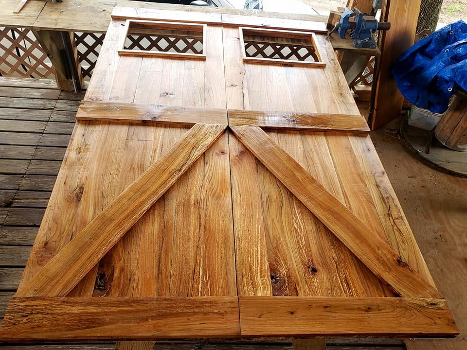 Custom oak barn doors built from milled lumber, with lattice windows