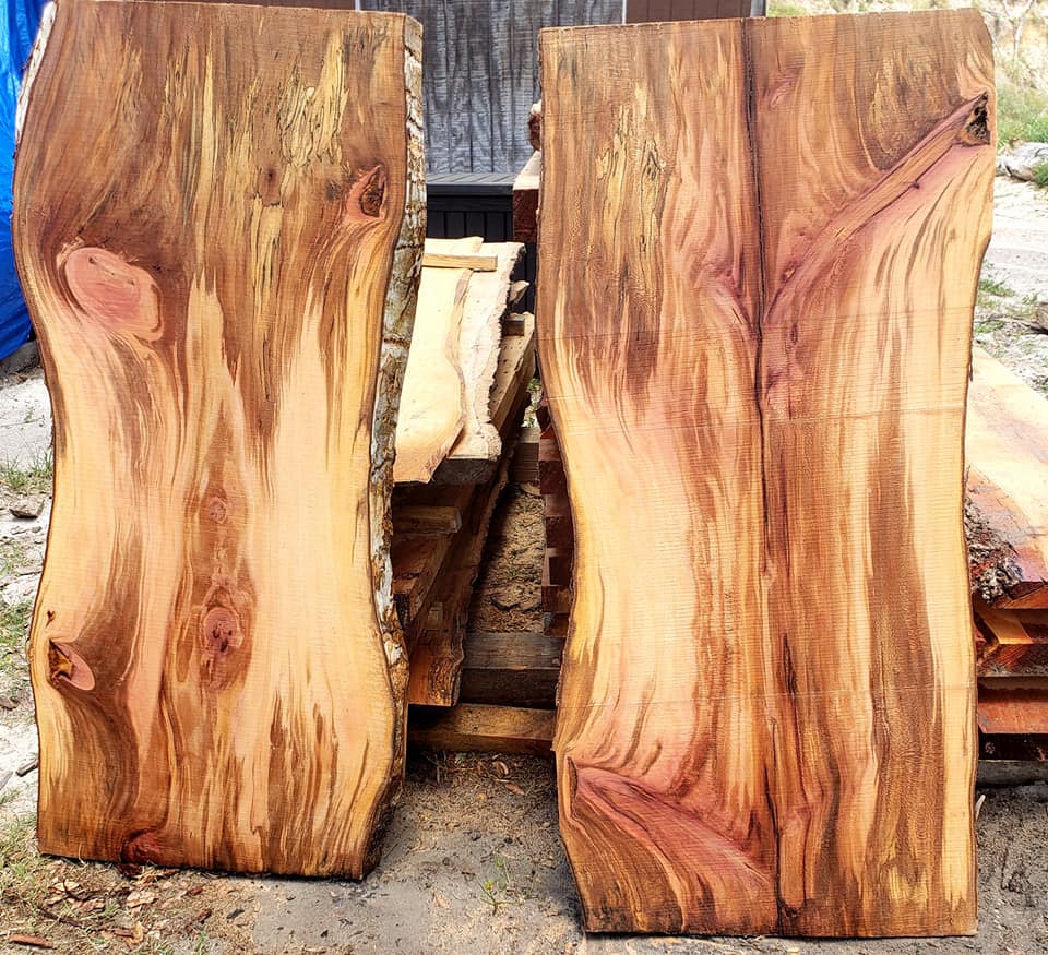 Two matching live-edge slabs leaning against the drying stack