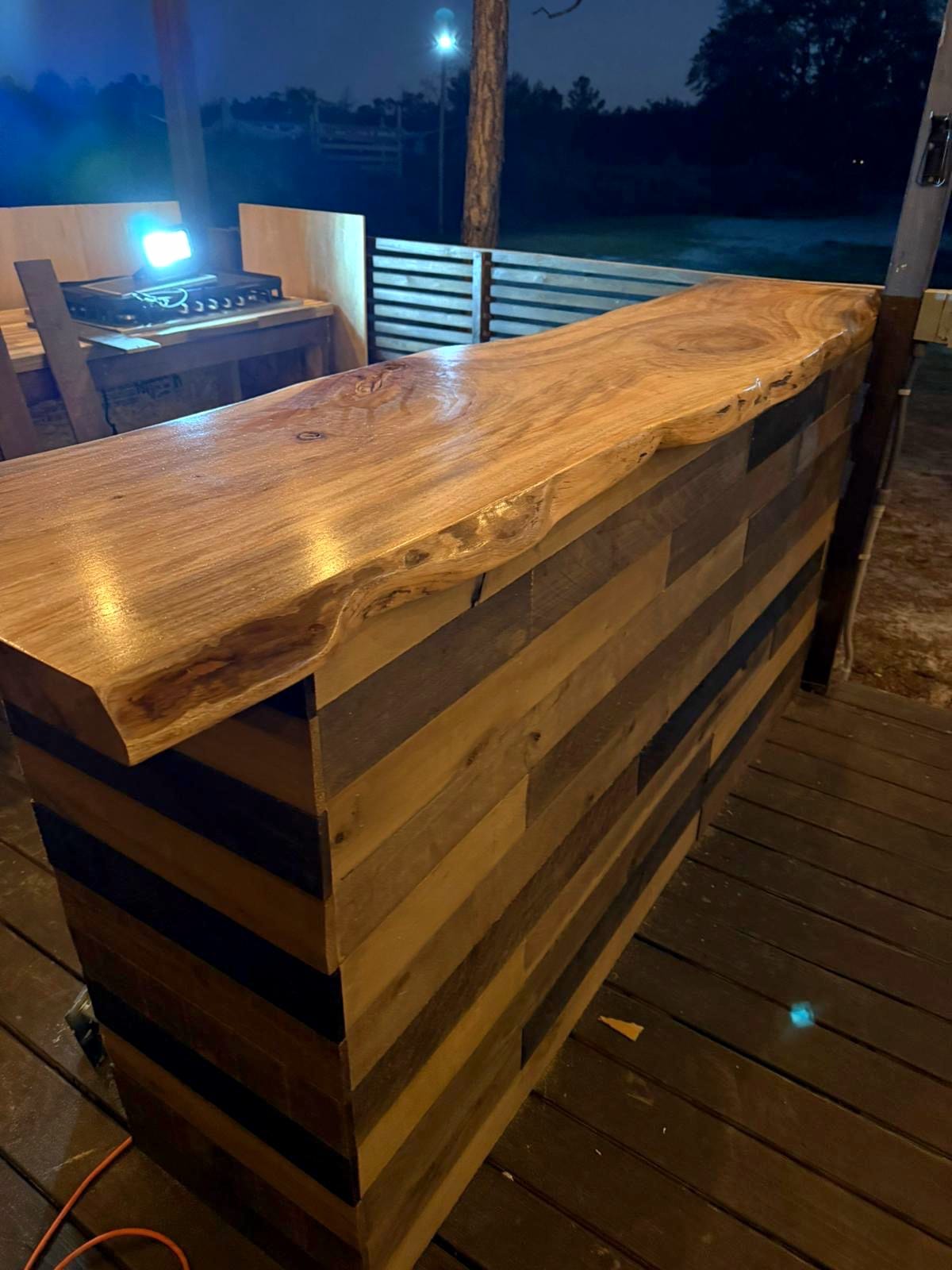 Live-edge slab installed as an outdoor bar top