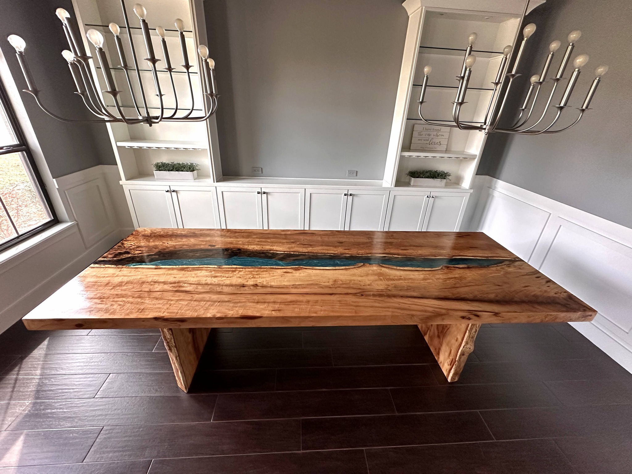 Camphor live-edge dining table with blue resin river fill, finished and installed in a residential dining room