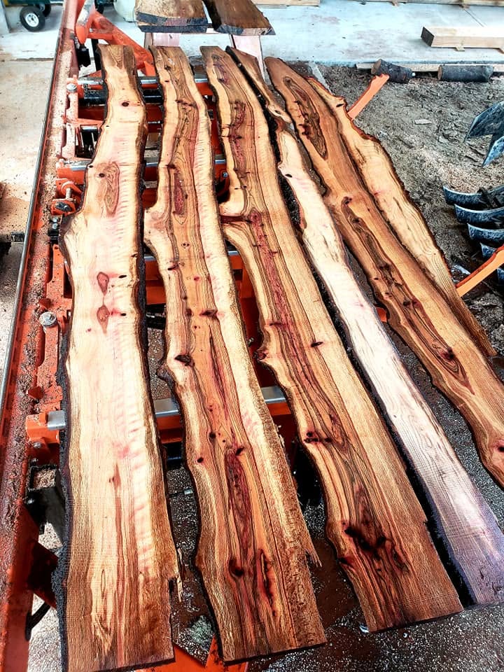 A rack of fresh-milled live-edge slabs with dramatic figure on the sawmill