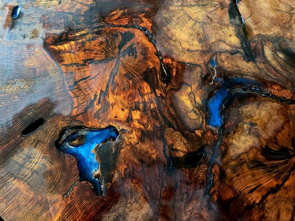 Figured burl table top finished in clear epoxy with deep blue resin pours
